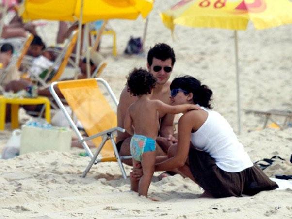 Mesmo sem sol, Daniel de Oliveira e Vanessa Giácomo não dispensam a praia
