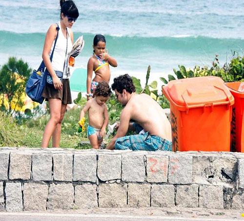 Vanessa Giácomo observa Daniel de Oliveira lavando o pézinho do pequeno Raul