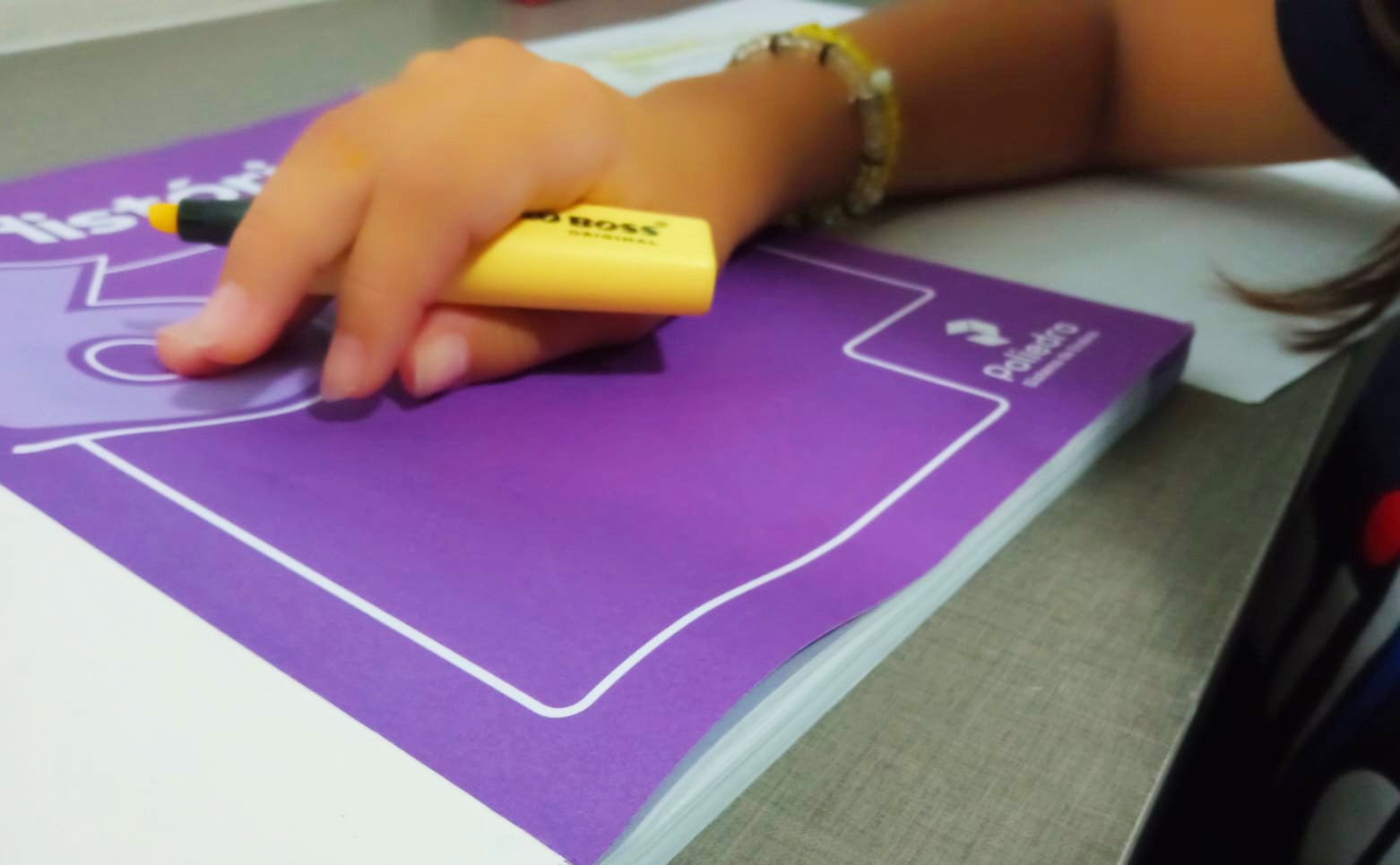 Criança em escola de São José dos Campos com o livro didático em mãos (Foto: OsPaparazzi)